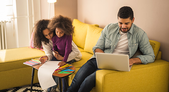 Young family in living room with laptop